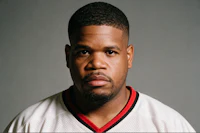 a man in a red and white jersey is posing for a photo